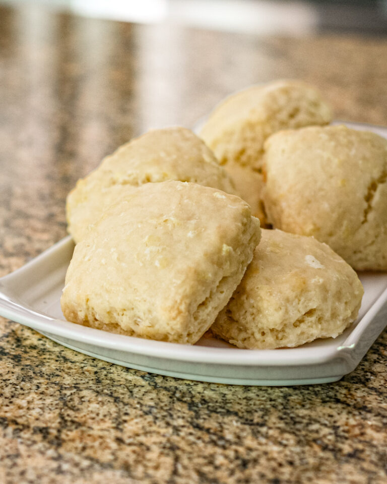 Glazed lemon scones on a white tray.