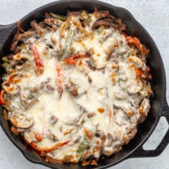 Philly cheesesteak cooked in the skillet with melted cheese topping.