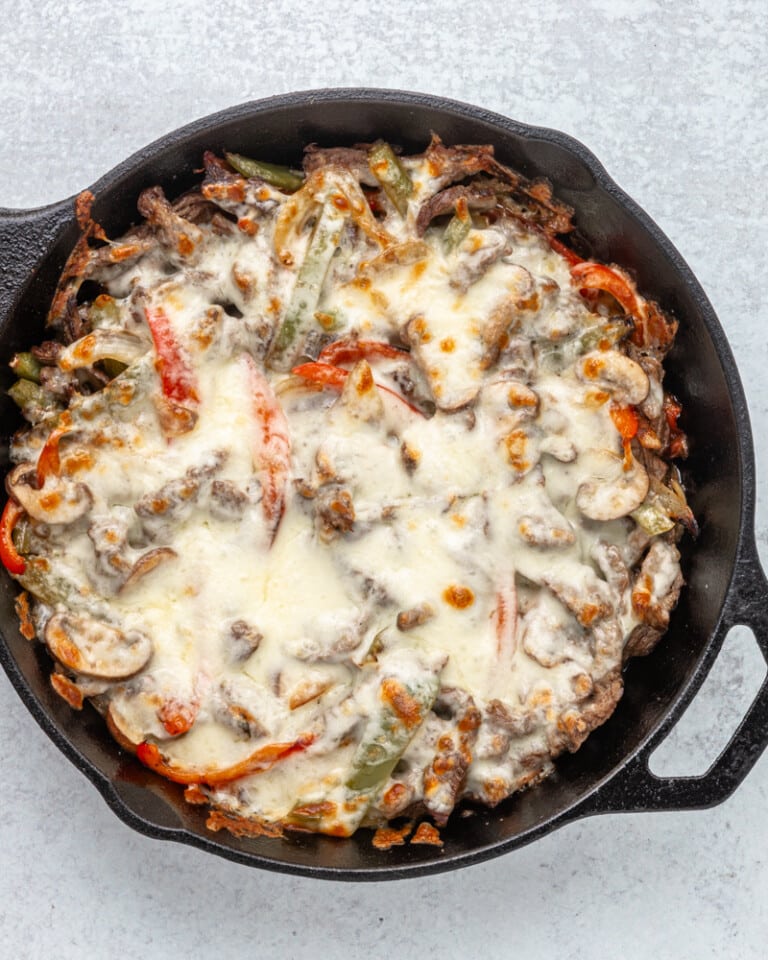 Philly cheesesteak cooked in the skillet with melted cheese topping.