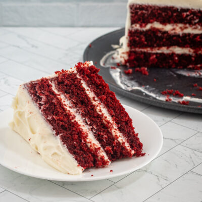 A big slice of red velvet cake with cream cheese frosting