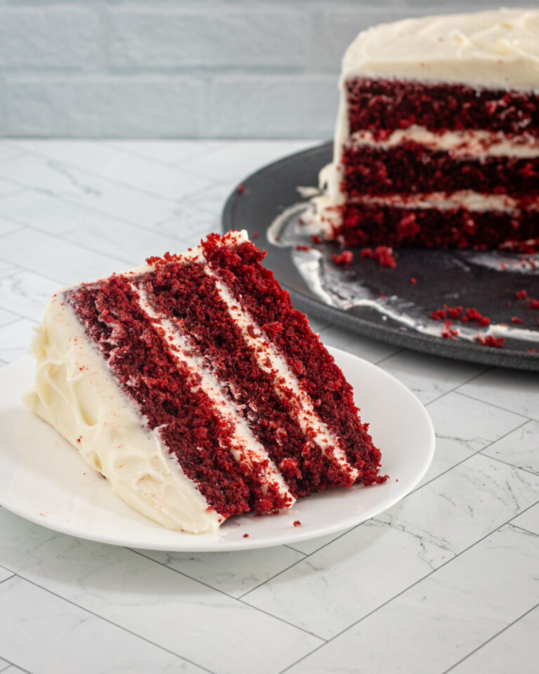 A big slice of red velvet cake with cream cheese frosting