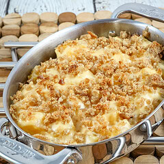 A baking dish with rutabaga gratin with breadcrumb topping and cheese.