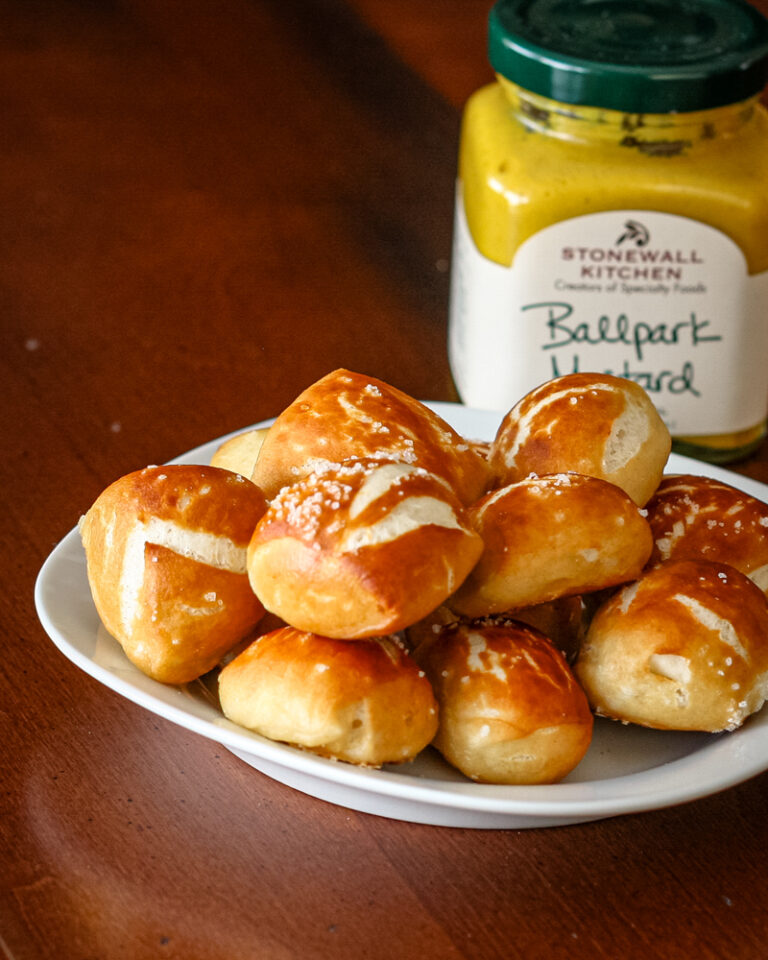 Homemade pretzel bites with mustard in the background.