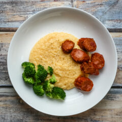 Polenta with spicy andouille sausage on a plate