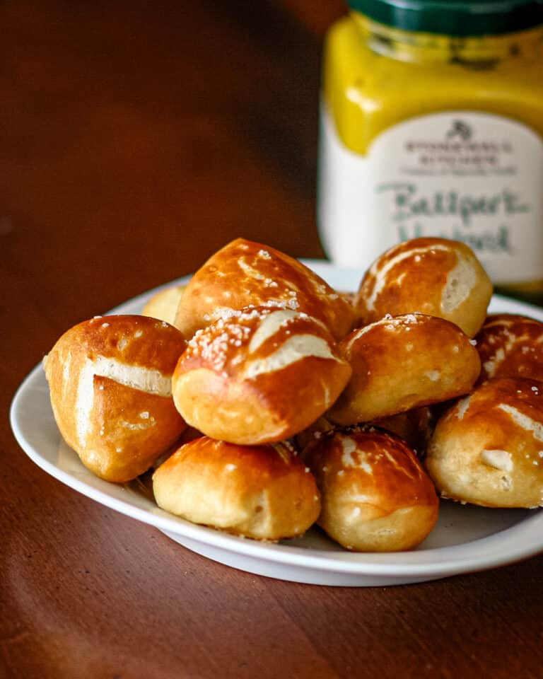 Homemade pretzel bites with mustard in the background.