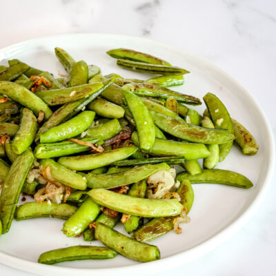 Roasted sugar snap peas on a plate.