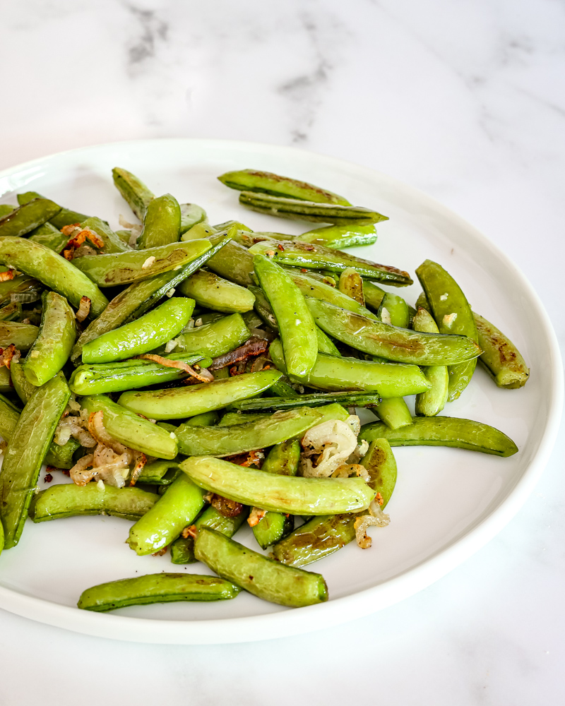 Roasted sugar snap peas on a plate.