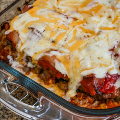 seven layer ground beef casserole with melted cheese on top