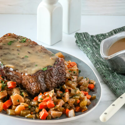 slow cooker pot roast and gravy surrounded by diced vegetables.