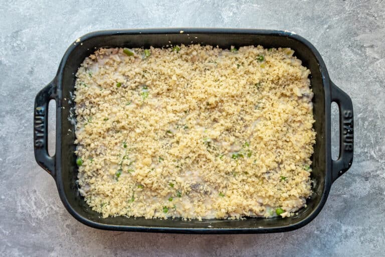 Tuna casserole with orzo in a baking dish with breadcrumb topping, ready to bake