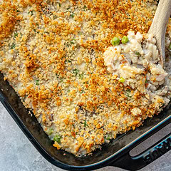 A baking dish with tuna casserole topped with buttered breadcrumbs.