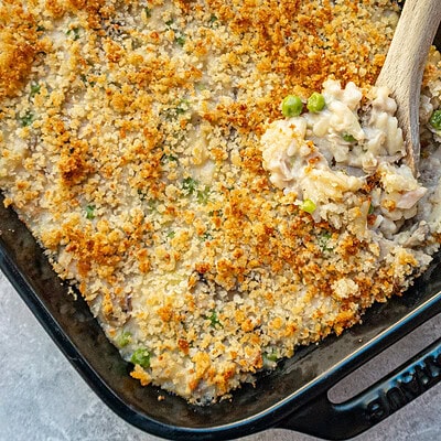 A baking dish with tuna casserole topped with buttered breadcrumbs.