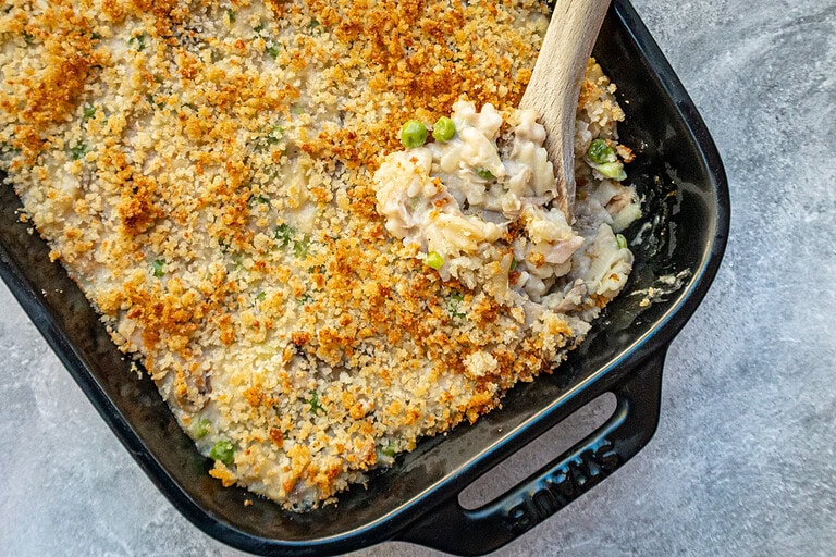 A baking dish with tuna casserole topped with buttered breadcrumbs.