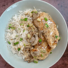 Apple brandy chicken on a bed of rice with mushrooms and green onions