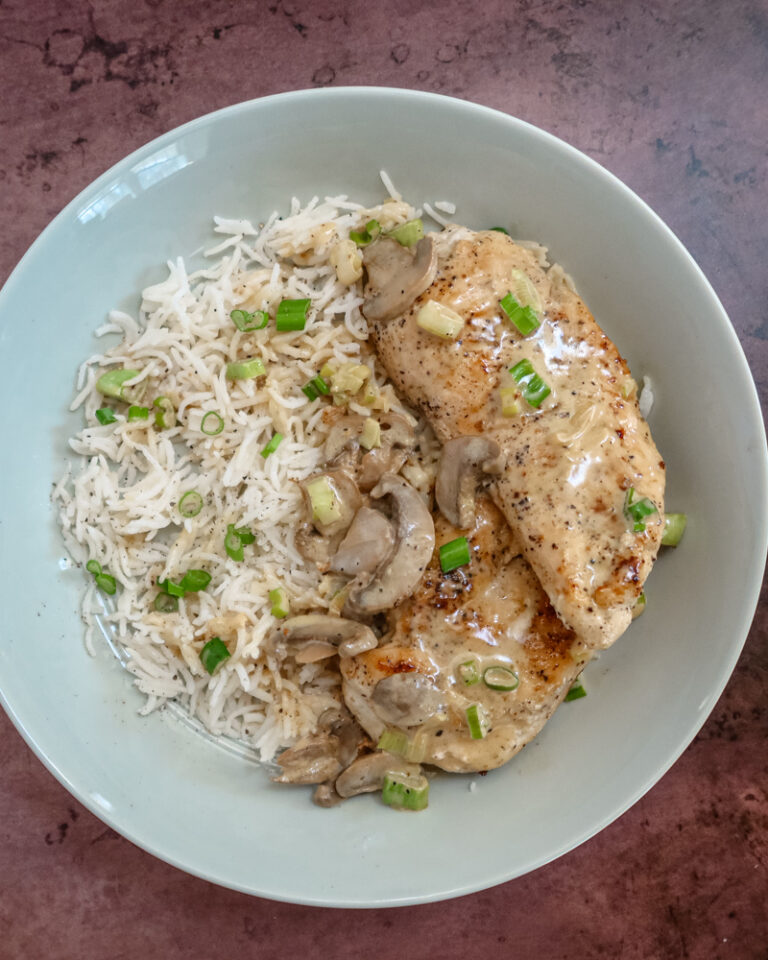 Apple brandy chicken on a bed of rice with mushrooms and green onions