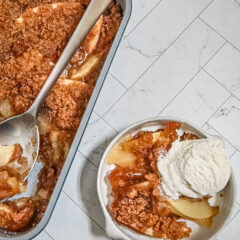 Apple betty in the baking pan with a serving beside it.
