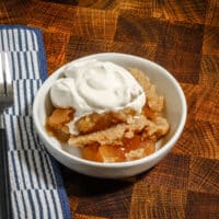 Apple cake shown with a dollop of whipped cream.