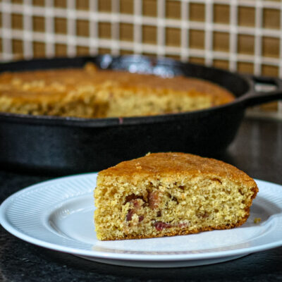 Bacon cornbread wedge on a plate.