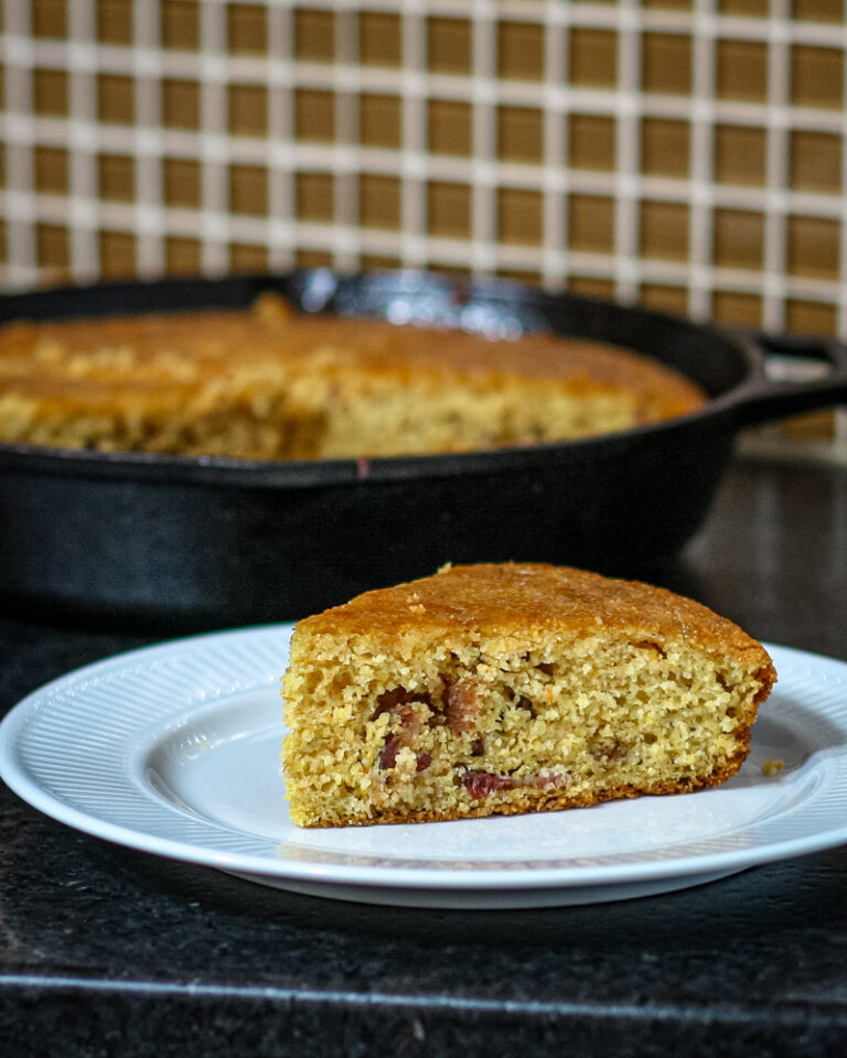 Bacon cornbread wedge on a plate.
