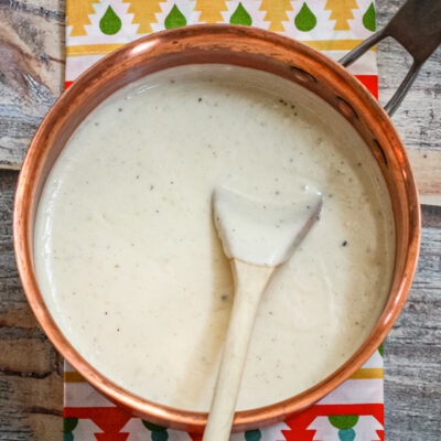 a basic white sauce in a copper saucepan
