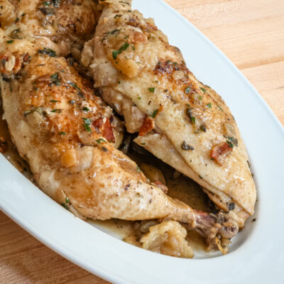 oven braised chicken with bacon and apples on a serving platter