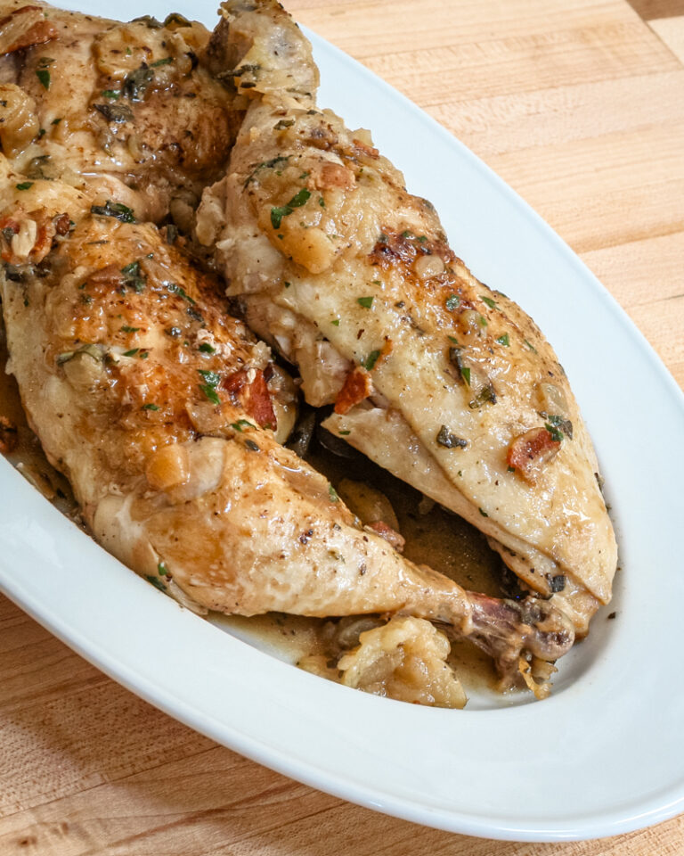 oven braised chicken with bacon and apples on a serving platter