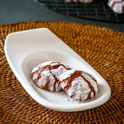 Chocolate crinkle cookies on a small serving plate.