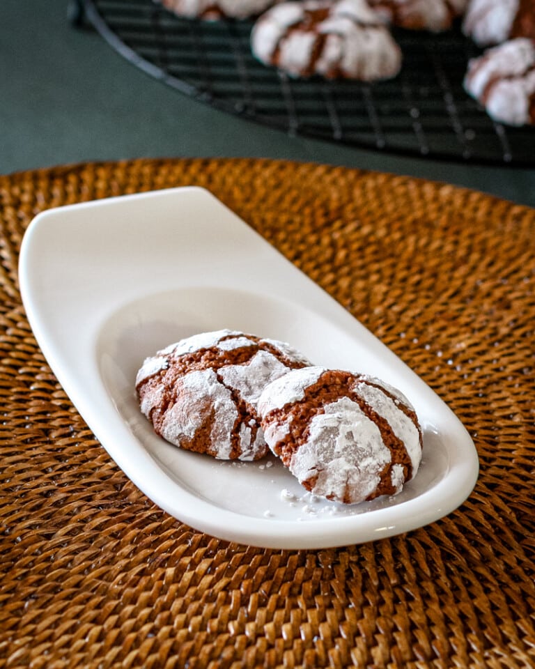Chocolate crinkle cookies on a small serving plate.