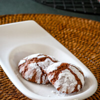 Chocolate crinkle cookies on a small serving plate.