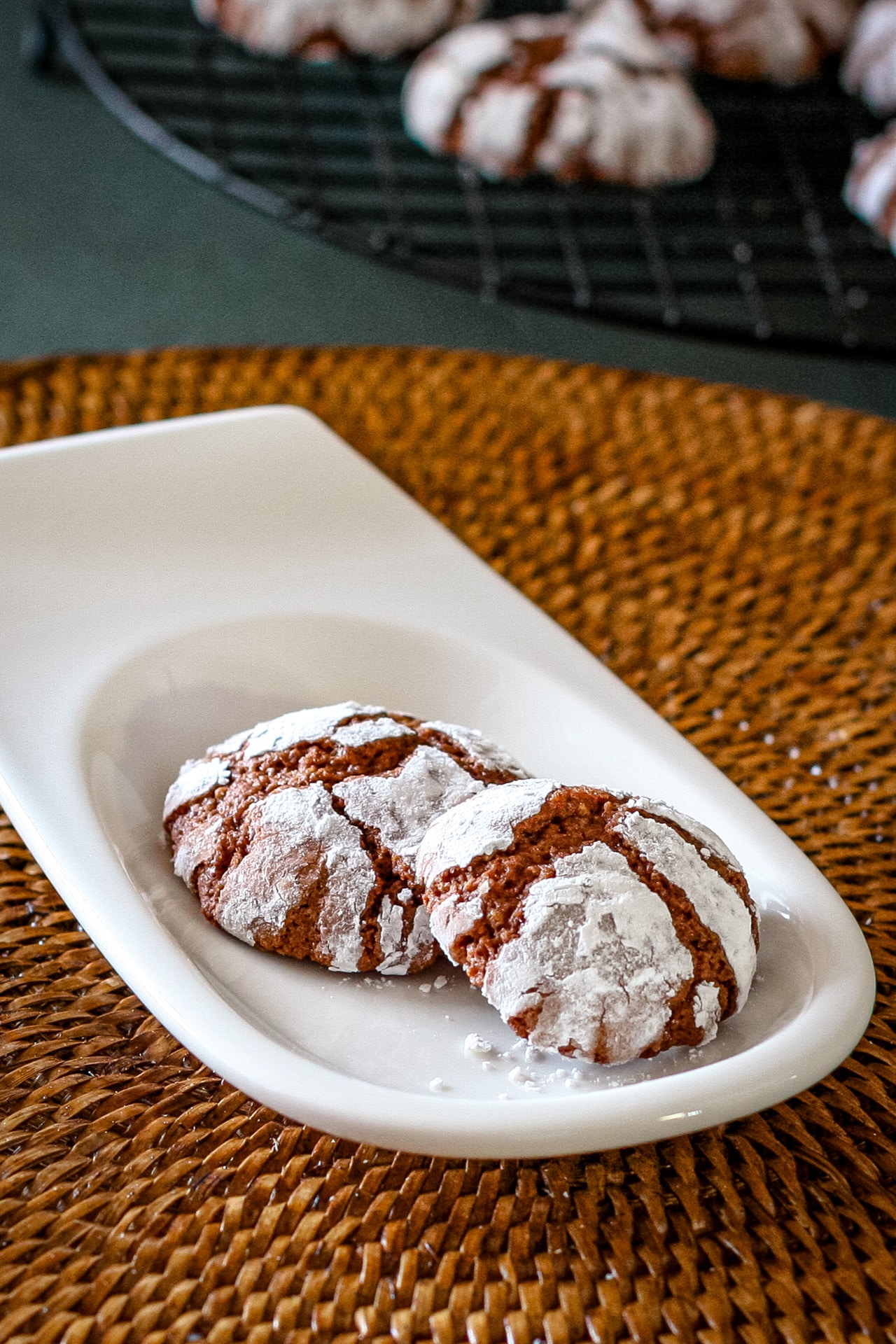 Chocolate crinkle cookies on a small serving plate.