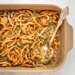 A baking dish with green bean casserole topped with crispy fried onions.