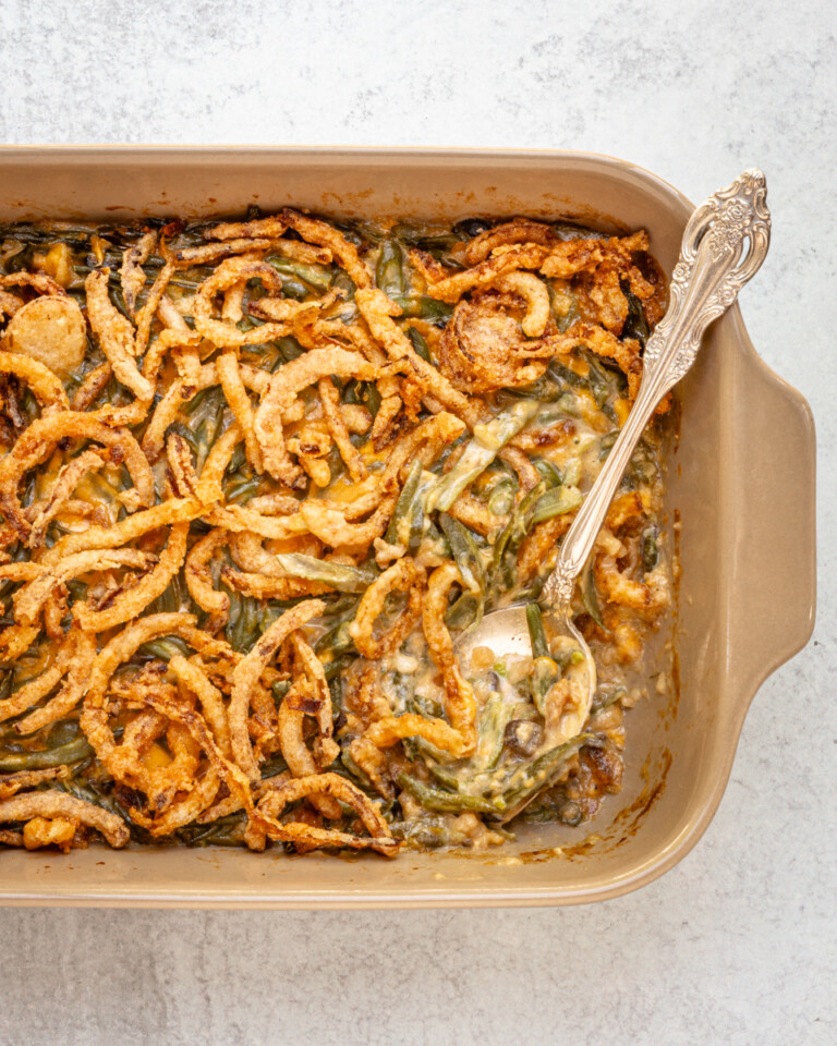 A baking dish with green bean casserole topped with crispy fried onions.