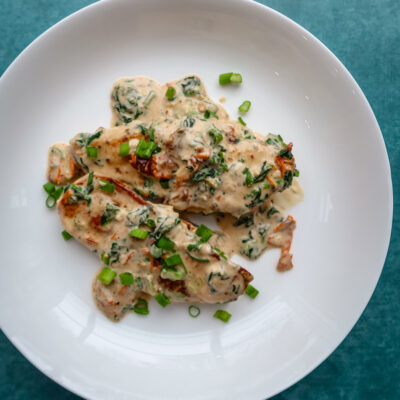 Creamy Tuscan chicken on a plate.