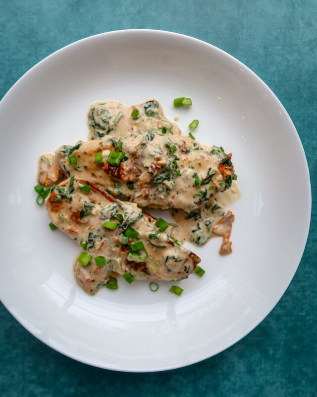 Creamy Tuscan chicken on a plate.
