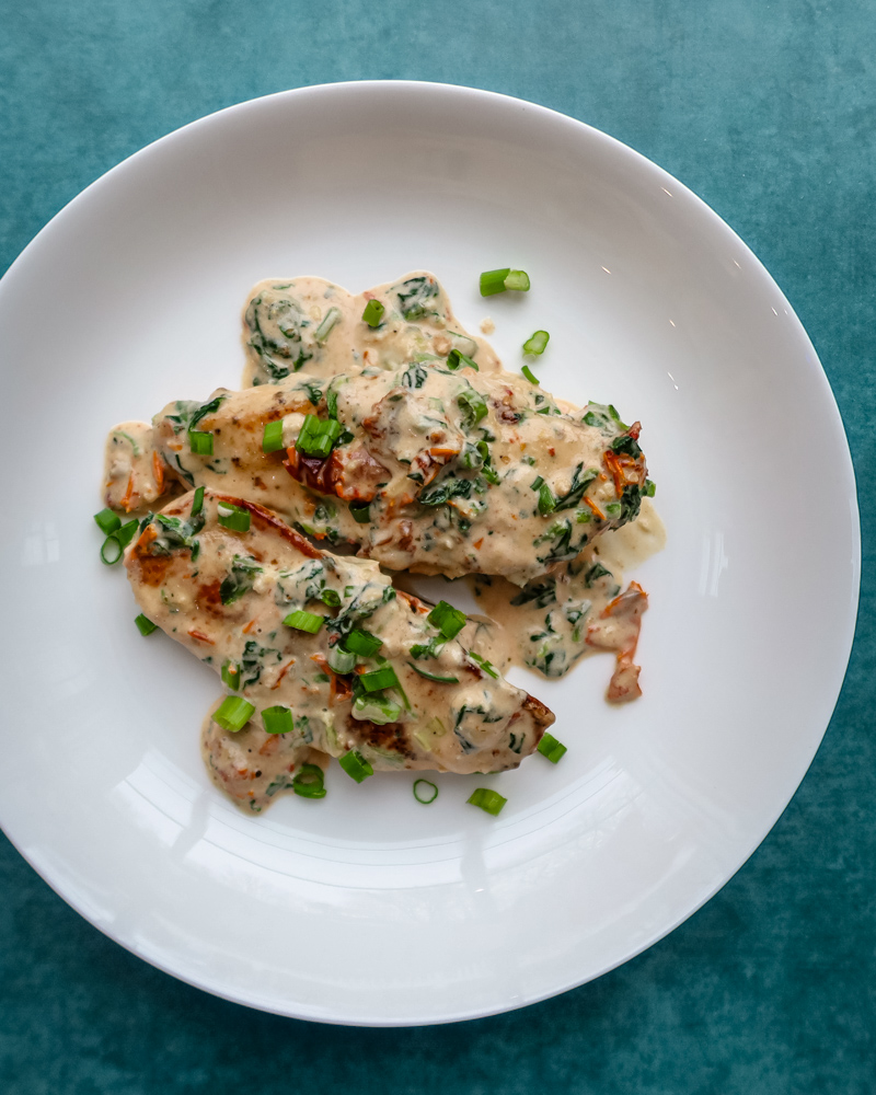 Creamy Tuscan chicken on a plate.
