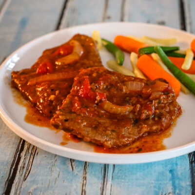 A serving of Swiss steak with vegetables.