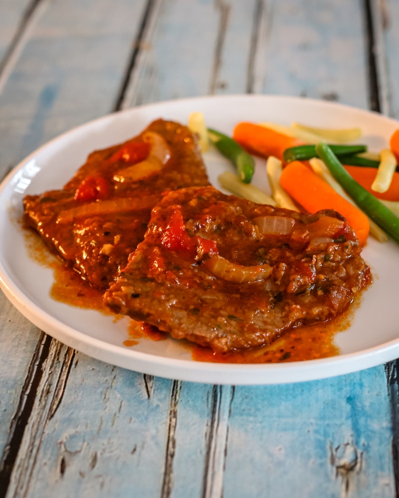 A serving of Swiss steak with vegetables.