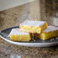 A plate of lemon bars topped with confectioners' sugar.