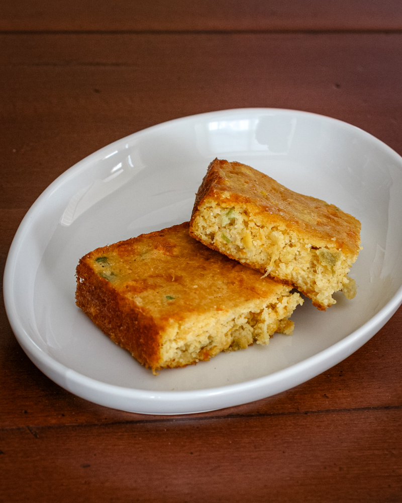 2 slices o Mexican cornbread in a dish.