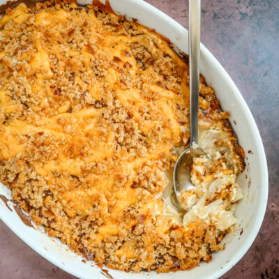 A baking dish with potatoes au gratin topped with cheese and breadcrumbs.