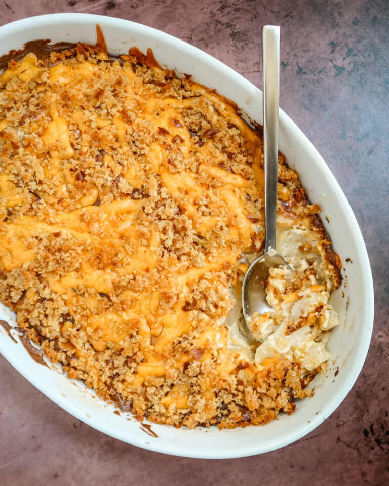 A baking dish with potatoes au gratin topped with cheese and breadcrumbs.