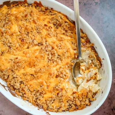 baking dish with potatoes au gratin topped with cheese and breadcrumbs.