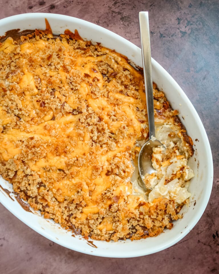 baking dish with potatoes au gratin topped with cheese and breadcrumbs.