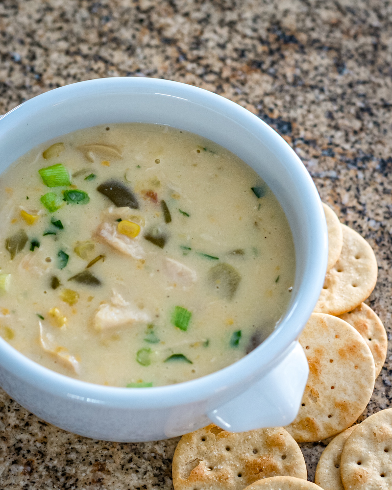 Creamy chicken soup with vegetables and green onions.