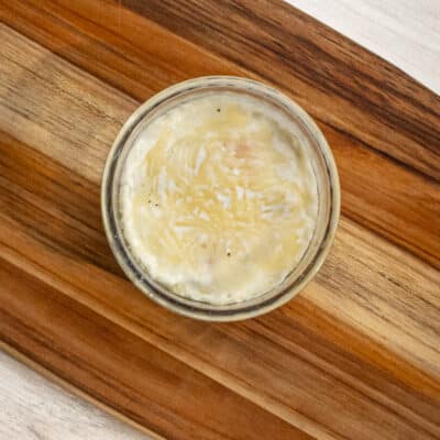 Shirred eggs baked in a glass ramekin with cheese topping.