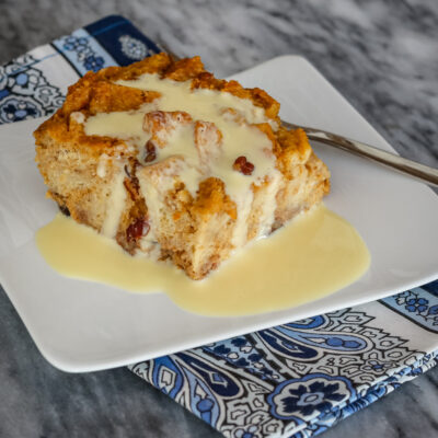 A slice of sweet potato bread pudding with vanilla sauce