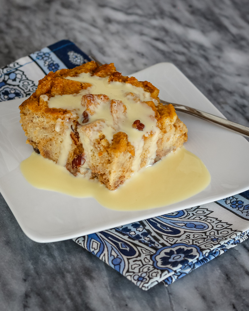 A slice of sweet potato bread pudding with vanilla sauce