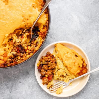 Overhead shot of a tamale pie with cheese topping and ground beef filling.