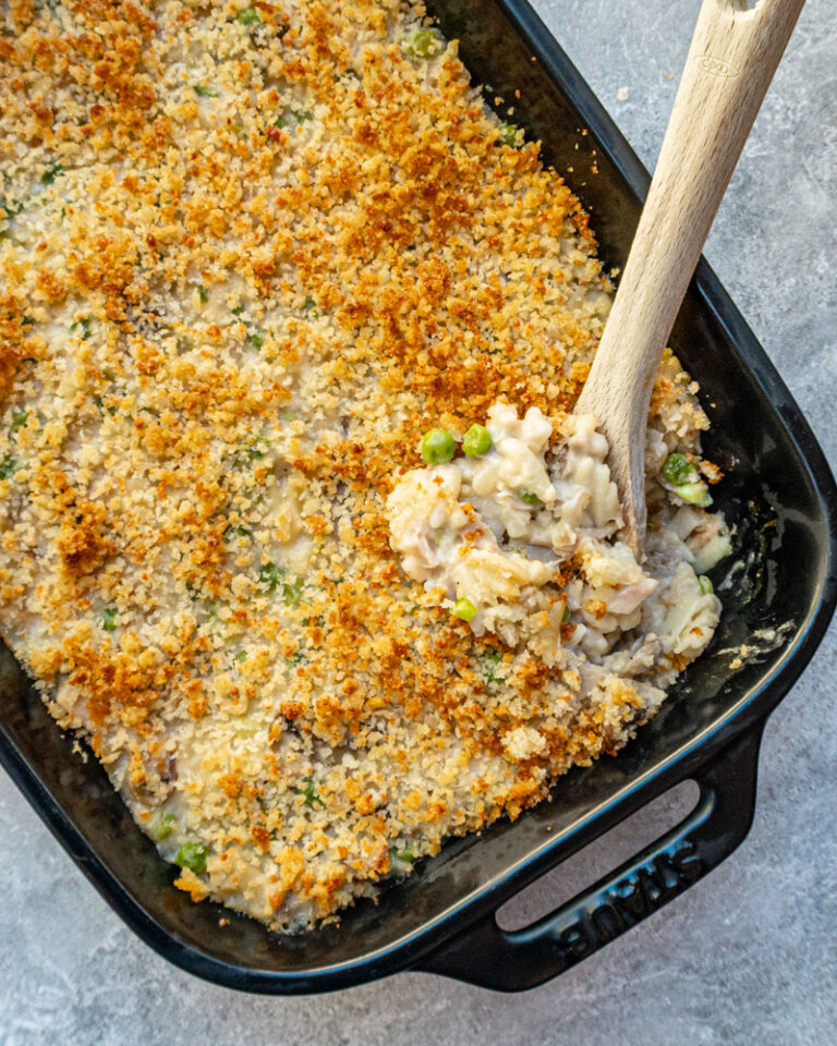 A baking dish with tuna casserole topped with buttered breadcrumbs.
