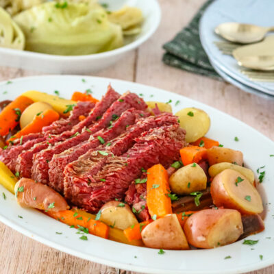 corned beef on a platter with potatoes, carrots, and cabbage on a